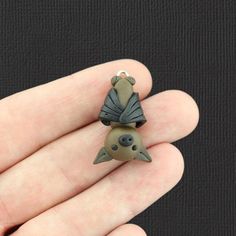 a hand holding a tiny animal brooch in it's palm