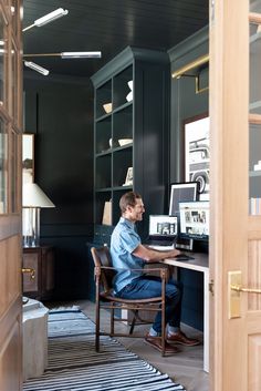 a man sitting at a desk in front of a book shelf with books on it