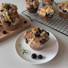 blueberry muffins on a cooling rack with fresh berries