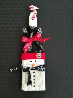 an ornament made to look like a snowman wearing a hat and scarf