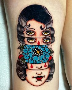 a woman's leg with an artistic tattoo design on her thigh and the face of a