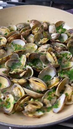 clams are being cooked in a pan on the stove