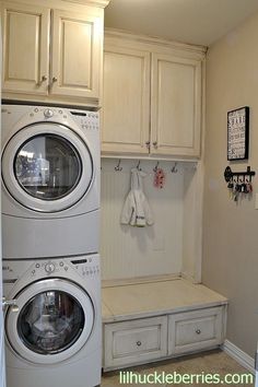 a washer and dryer in a laundry room with cabinets on either side of the washer and dryer