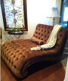 a brown couch sitting on top of a hard wood floor