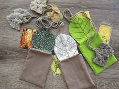 four pieces of cloth with leaves on them sitting on top of a wooden table next to each other