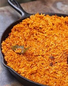 a skillet filled with rice on top of a table