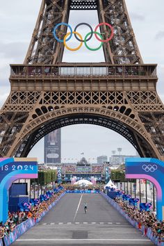 the eiffel tower in paris, france is decorated with olympic symbols and people taking pictures