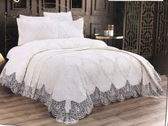 an image of a bed with white comforter and pillows on it's side