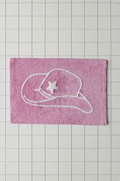 a pink bath mat with a white hat on it and a star in the middle