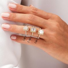 a woman's hand with three rings on her fingers and one ring in the middle