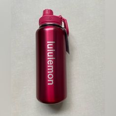 a red water bottle sitting on top of a white table