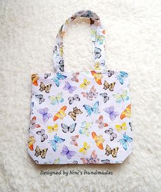 "Small Batch Handmade Kids Cotton Mini Totebag with a lovely Butterfly print fabric on the outside and a blend Orang me Polka dot fabric on the inside.  And butterfly cotton straps. Measures approximately 9.5\" wide x 8.5\" tall with 14\" straps. The bags are for older toddlers  ages 4 and up. Preschool age. Please supervise child with strapbag at all times." White Fabric School Bag, Everyday Butterfly Print Tote Bag, Rectangular Travel Bag With Butterfly Print, White Fabric Bag For Gifts, Preschool Age, Dot Fabric, Toddler Age, Handmade Kids, Polka Dot Fabric