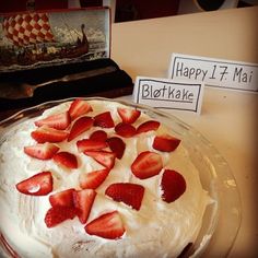 there is a cake with strawberries on it and a sign that says happy 1 / 4 mai blothake