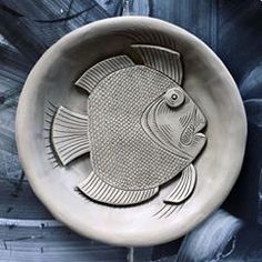 a bowl that has a fish on the inside of it and is painted in black and white