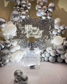 balloons and disco balls are on display in front of a mirror backdrop with the words let this party begin