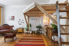 a living room filled with lots of furniture and a staircase leading up to the top floor