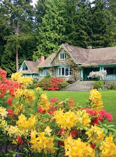 the house is surrounded by colorful flowers and trees