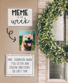 a bulletin board with some pictures on it next to a wreath and a sign that says meme of the week