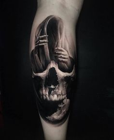 a man's leg with a skull tattoo on it and a person holding a knife