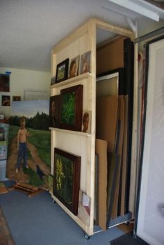 a room filled with pictures and paintings on the wall next to a doorway that leads to another room