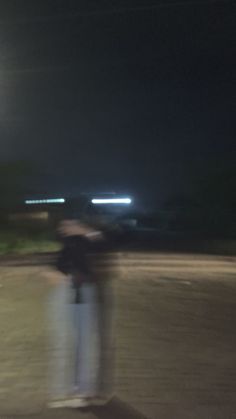 a blurry image of a person on a skateboard in the street at night