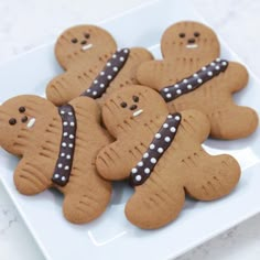 there are some cookies shaped like gingers on a white plate with polka dot trim