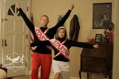 a man and woman are standing in the living room holding their arms up with one hand