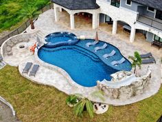 an aerial view of a swimming pool with lounge chairs