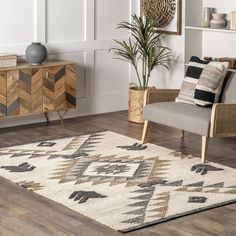 a living room area with a rug, chair and plant in the corner on the floor