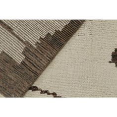 a rug with brown and white designs on the bottom, in two different colors that appear to be made from wool