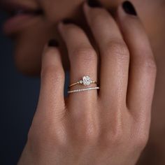 a woman's hand with a diamond ring on her finger and an engagement band