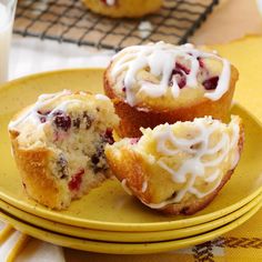 two muffins with white icing on a yellow plate