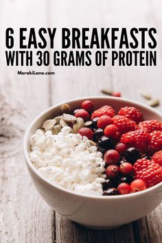 a bowl filled with cottage cheese, berries and nuts on top of a wooden table