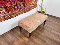 a bench sitting on top of a wooden floor next to a rug