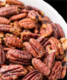 a white bowl filled with pecans sitting on top of a table