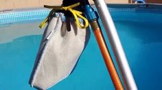 an umbrella sitting on the side of a swimming pool next to a metal pole and net