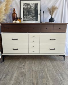 a white and brown dresser sitting on top of a wooden floor