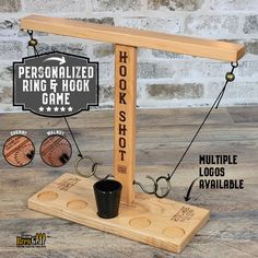 the personalized ring and hook game is made from wooden planks, with two cups on each side