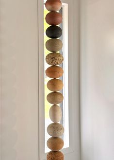 a stack of rocks sitting on top of a window sill in front of a white wall