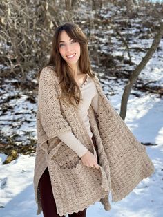 a woman standing in the snow wearing a cardigan