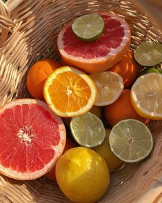 a basket filled with citrus fruit sitting on top of a table