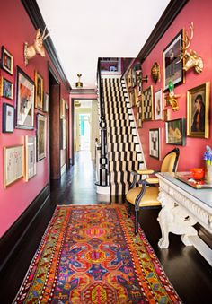 the hallway is decorated in pink and black with pictures hanging on the wall above it