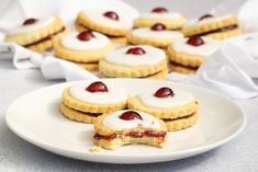 small cookies with cherries and cream filling on a white plate