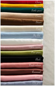 an assortment of different colored sheets on top of each other, with the names of them