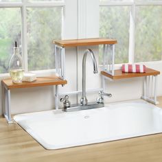 a kitchen sink with two wooden shelves on the side and a window in the background