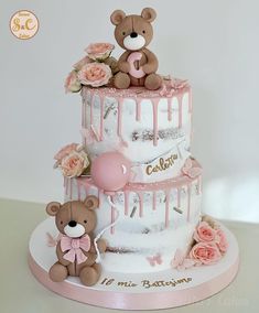 a three tiered cake decorated with teddy bears and pink flowers on the bottom layer