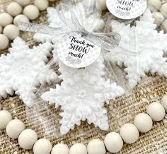 white snowflakes with thank you stickers on them sitting on burlap