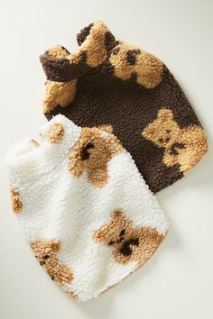 two baby hats with teddy bears on them, one is brown and the other is white