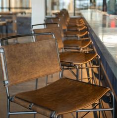 a row of chairs sitting next to each other at a bar with barstools