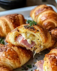 ham and cheese croissants on a plate with parsley sprinkled on top